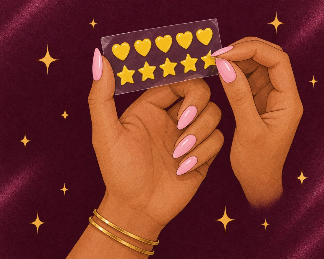 Mano despegando una pegatina de la lámina de corazones y estrellas amarillos, con las uñas rosas