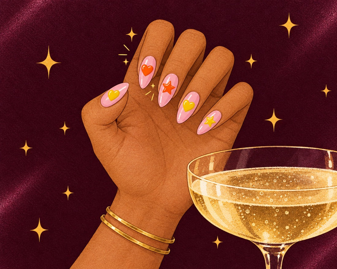 Mano con las uñas con pegatinas de corazón y estrella junto a una copa